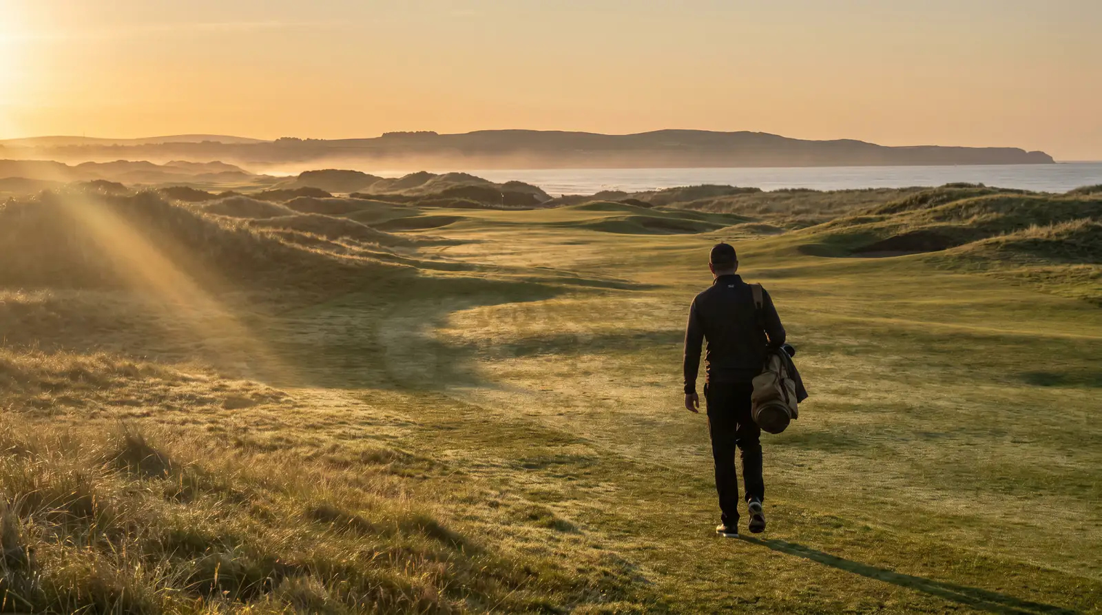 Golfer walking down a sunlit fairway at dawn representing each-way golf betting opportunities in professional tournaments