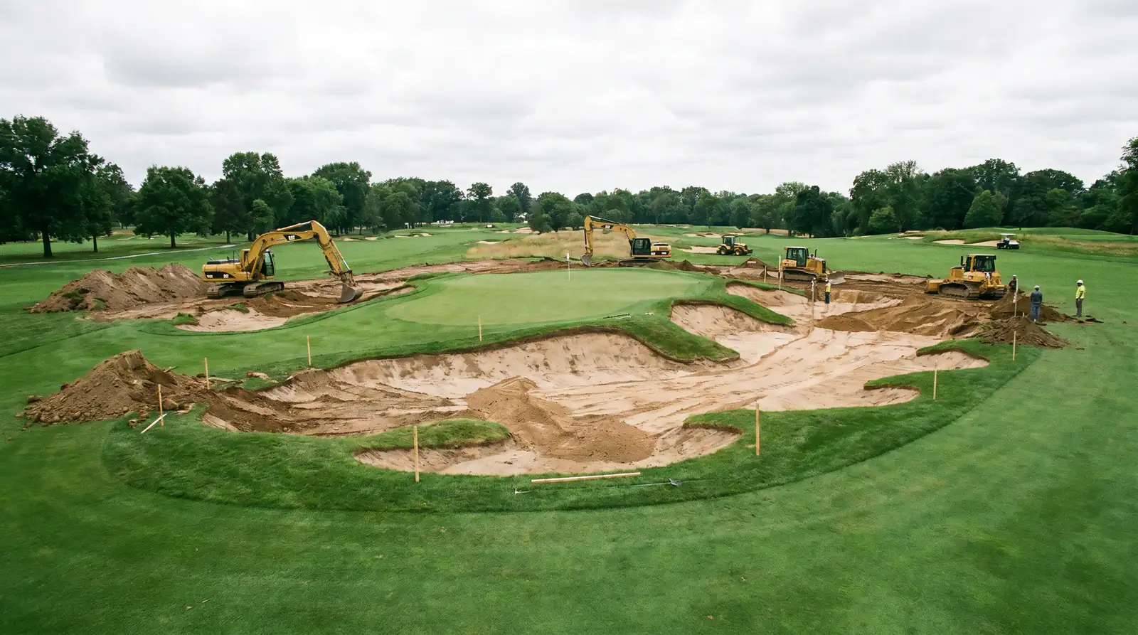 Golf course under renovation with construction equipment reshaping a green complex