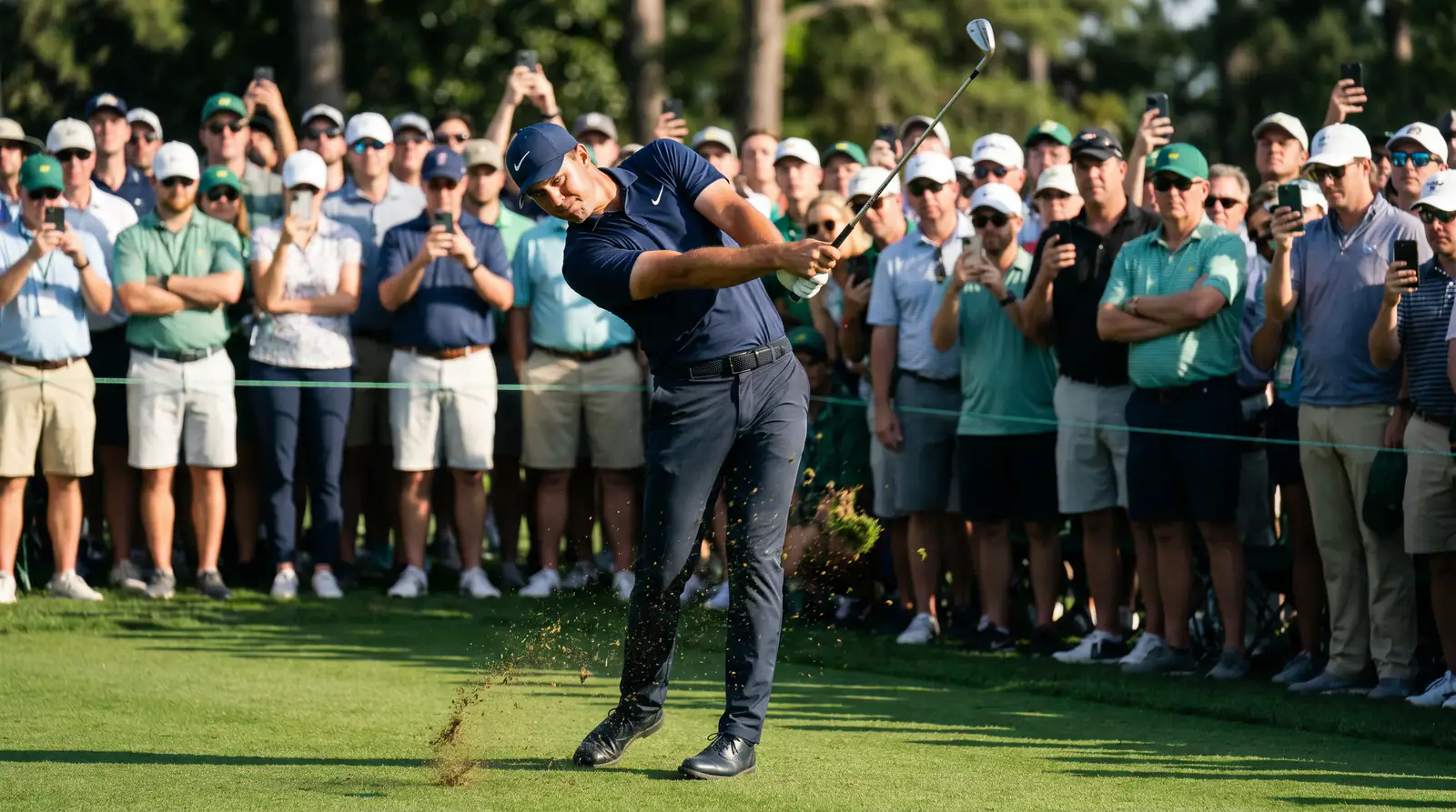 Golfer mid-swing during a live PGA Tour round with spectators watching intently from the gallery