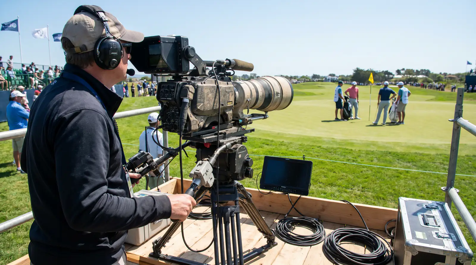 Television broadcast camera setup at a PGA Tour event capturing live tournament coverage