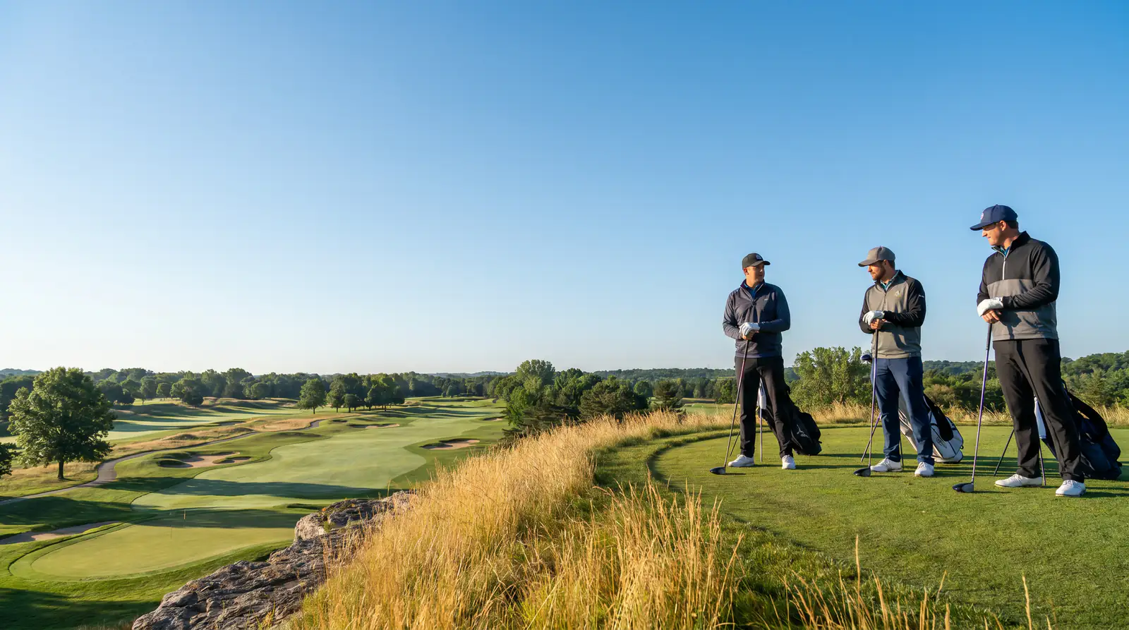 Three golfers standing together on a tee box representing a group matchup format